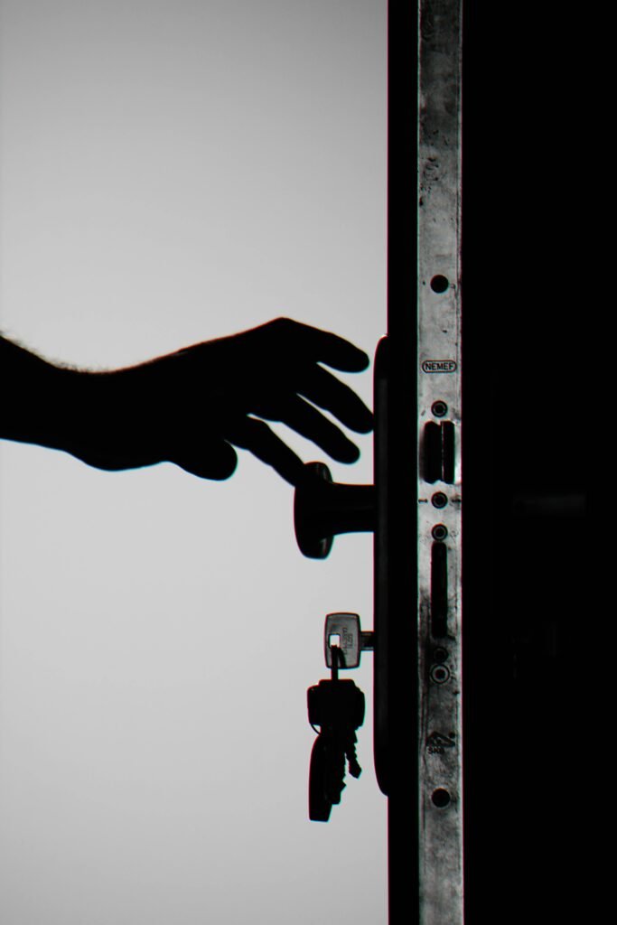 pexels-photo-792032-792032 Silhouette of a hand about to open a door with keys in lock, symbolizing security.